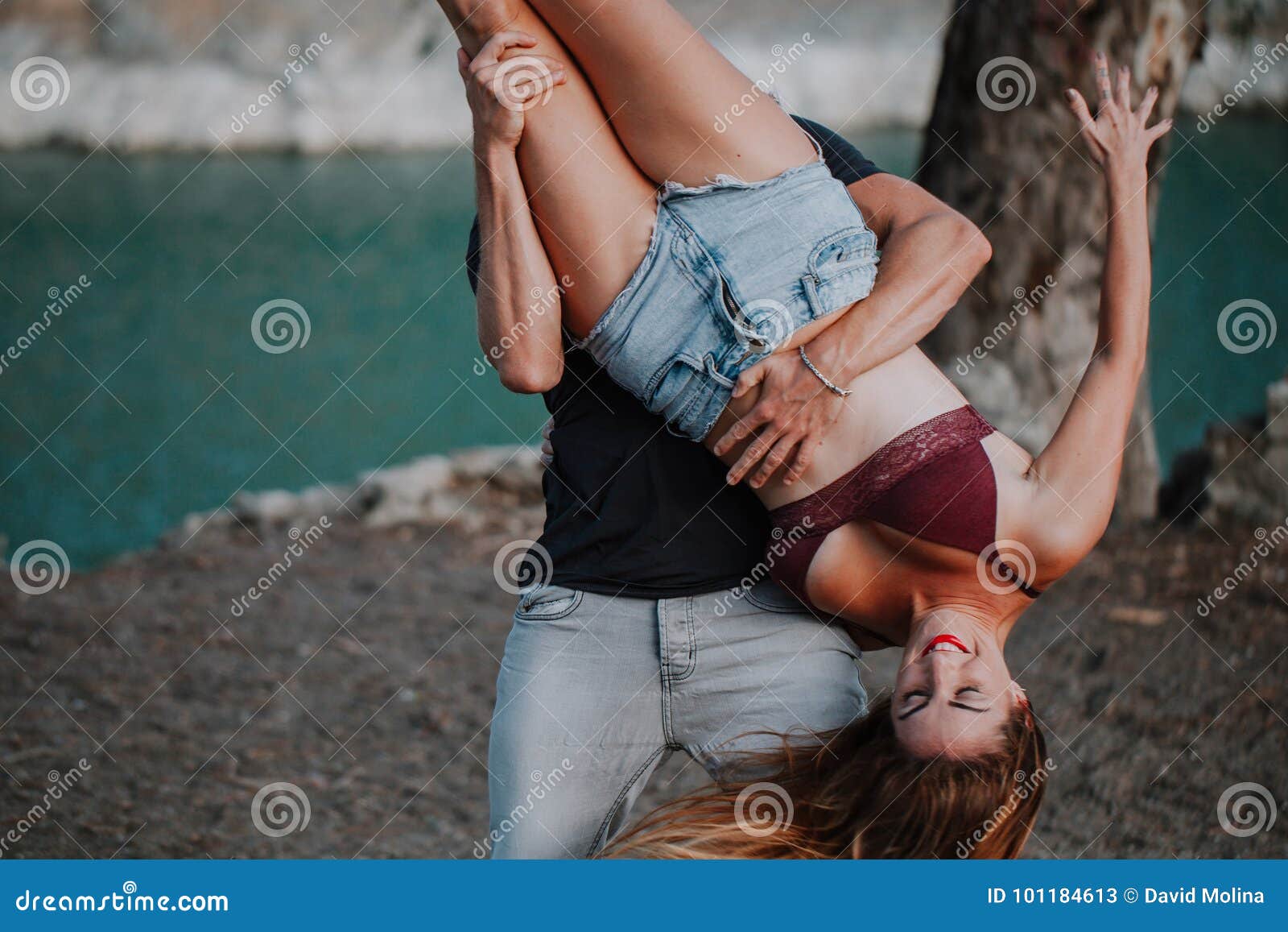 Мужчина держит девушку за ногу