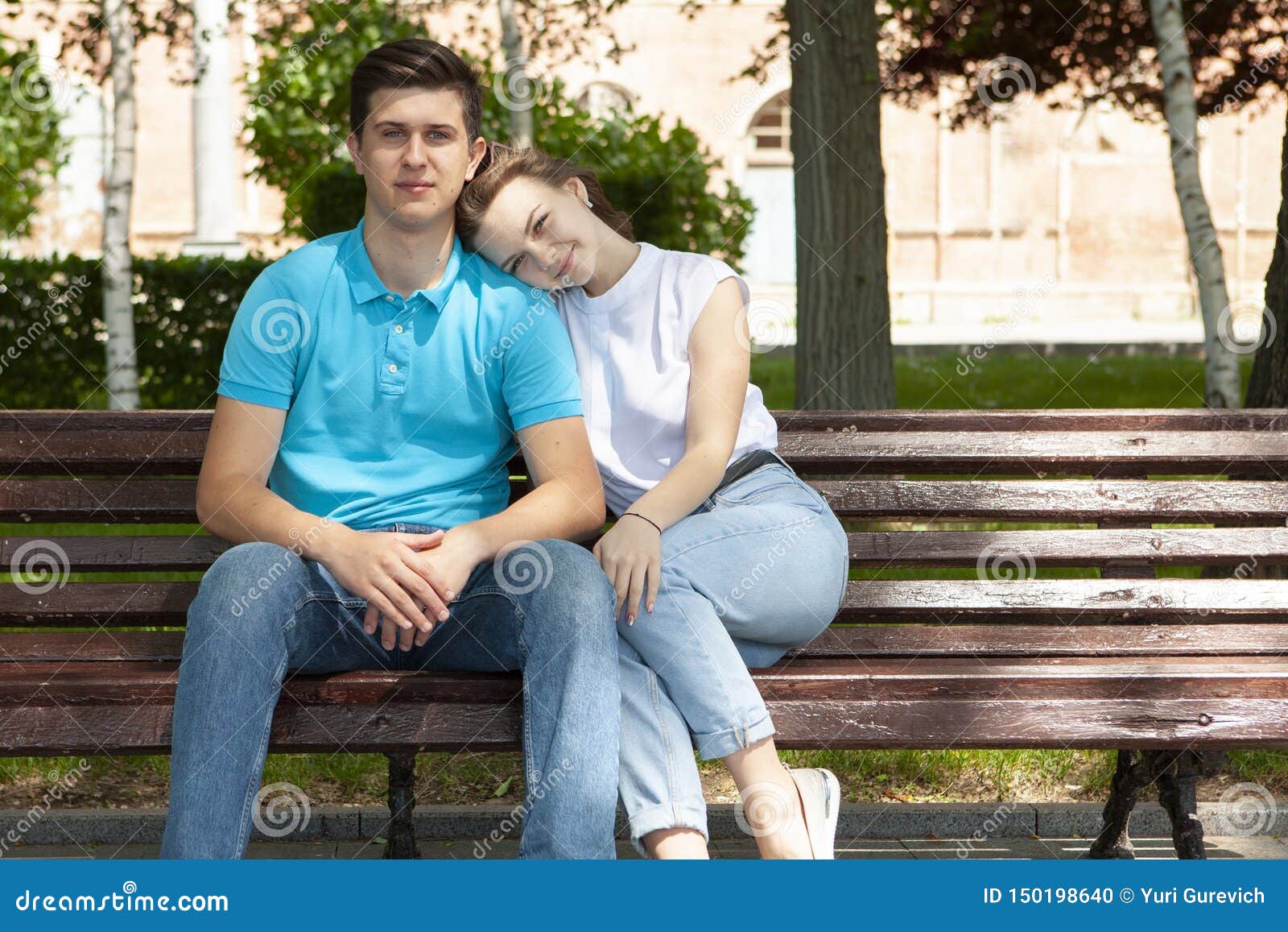 Мужчина сидит на плечах мужчины. Девушка положила голову на плечо. Положив голову на плечо. Парень и девушка сидят рядом. Пара на скамейке.